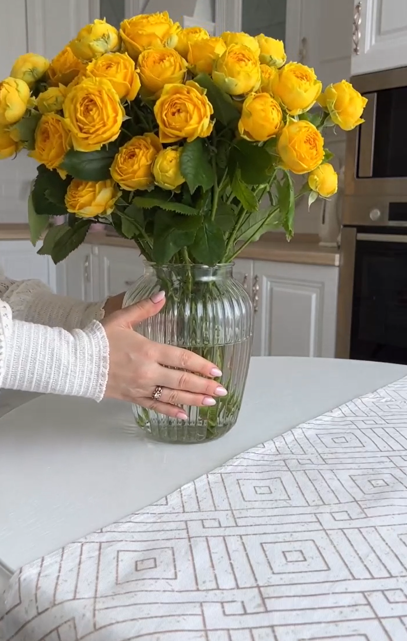 Breakfast with croissant, berries, teapot and yellow roses