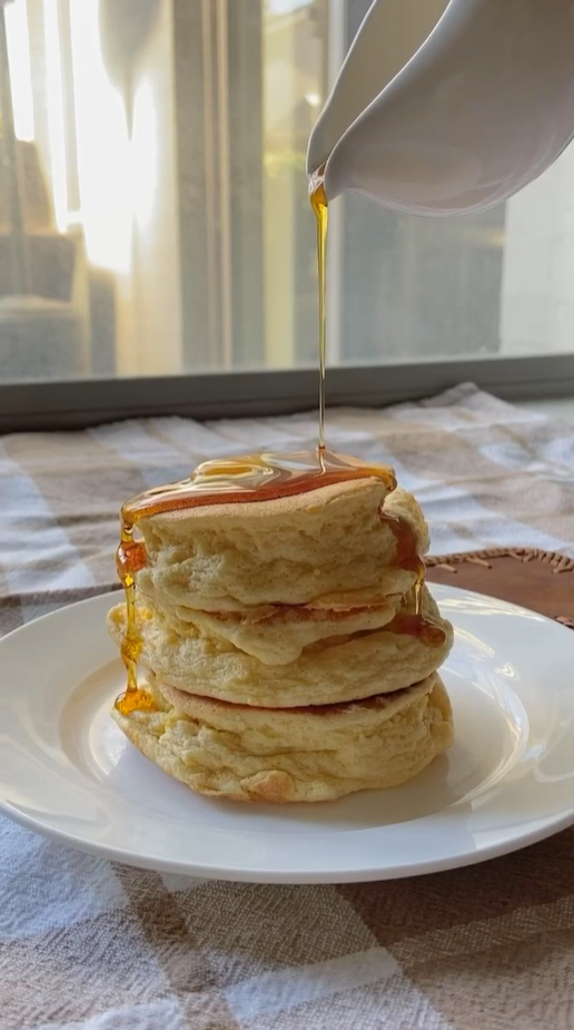 Fluffy pancake stack drizzled with golden syrup
