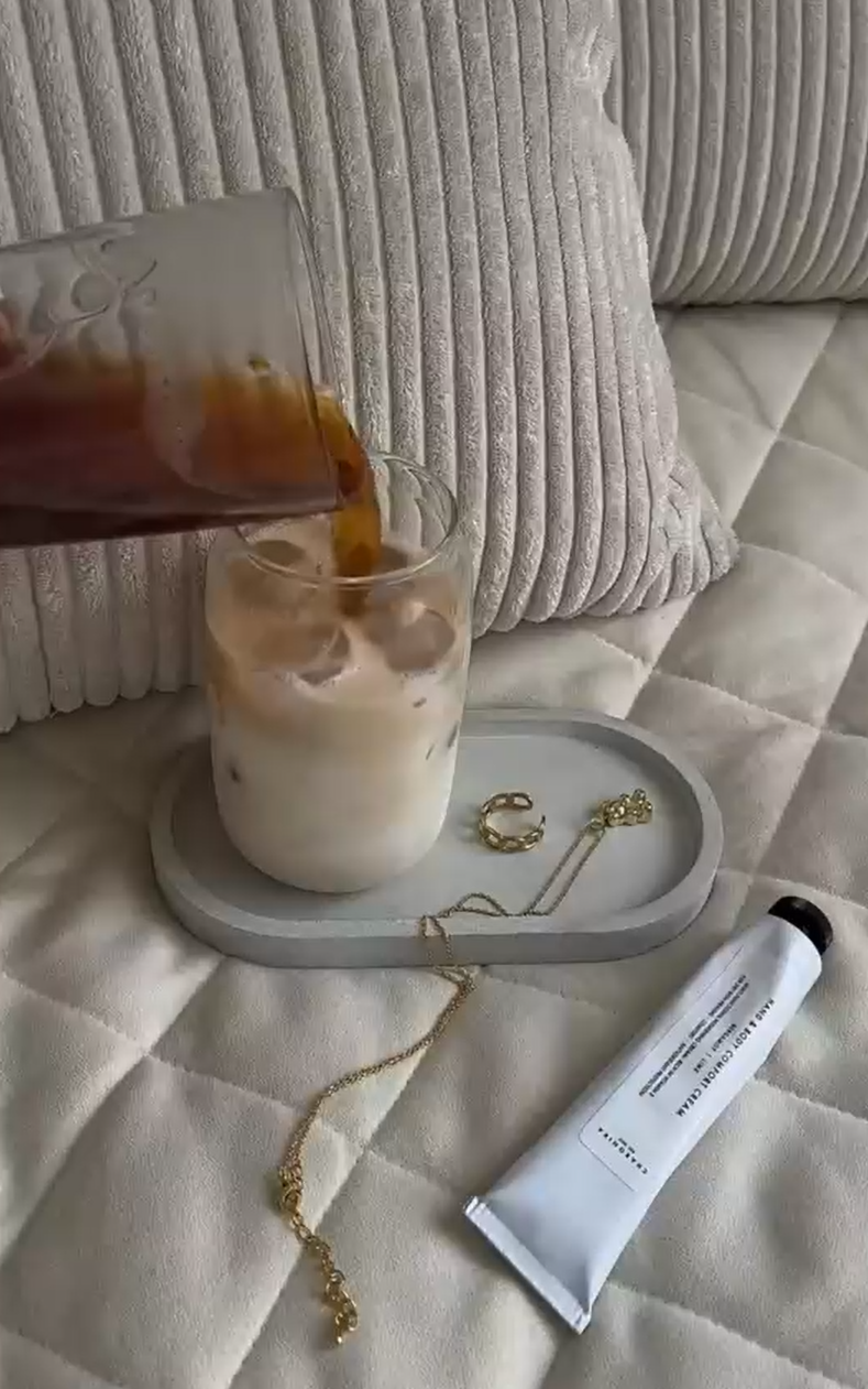 Pouring milk on a cosy bed with jewellery and skincare