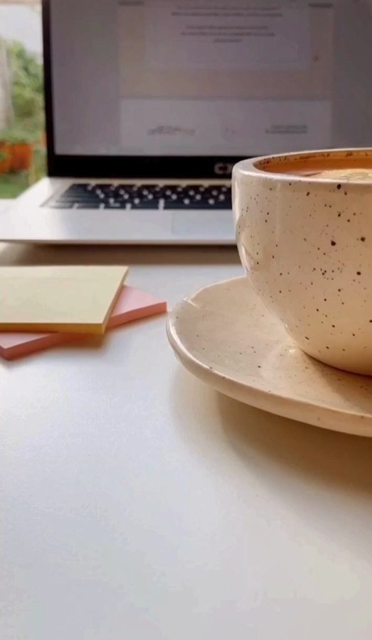 close up off coffee in front of laptop with post it notes on desk