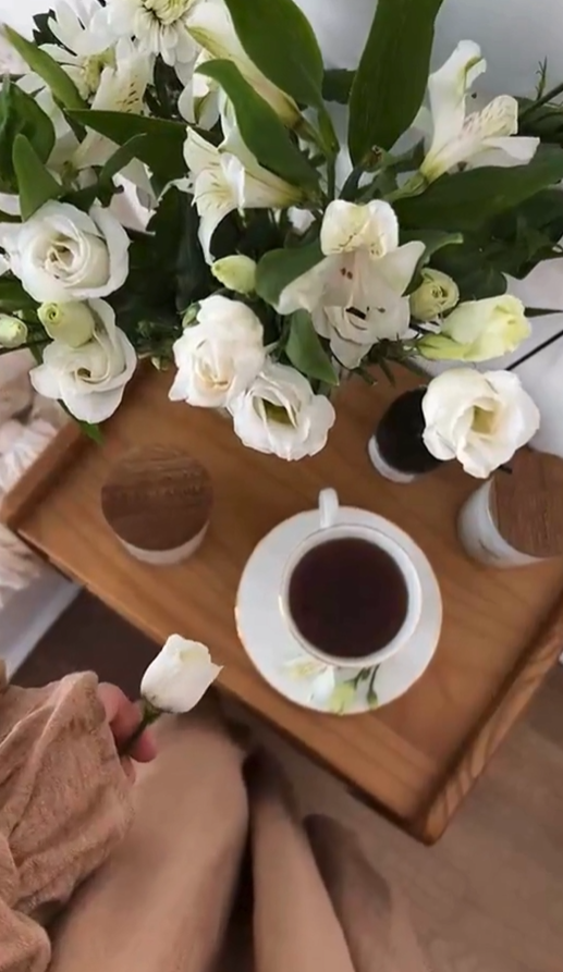 cuppa tea and flowers in vase on table single flower being twirled