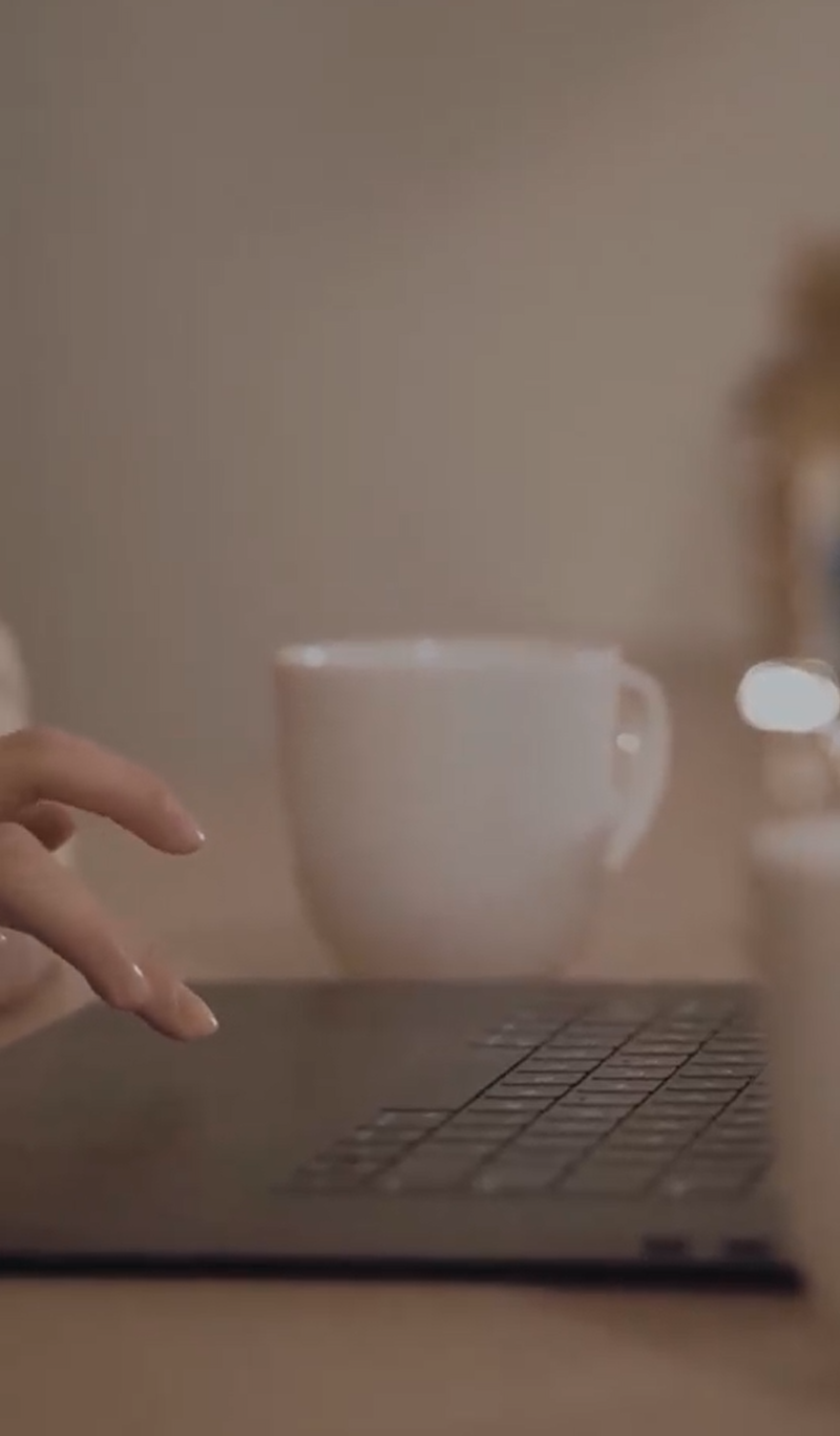 navigating touchpad on laptop with coffee on desk